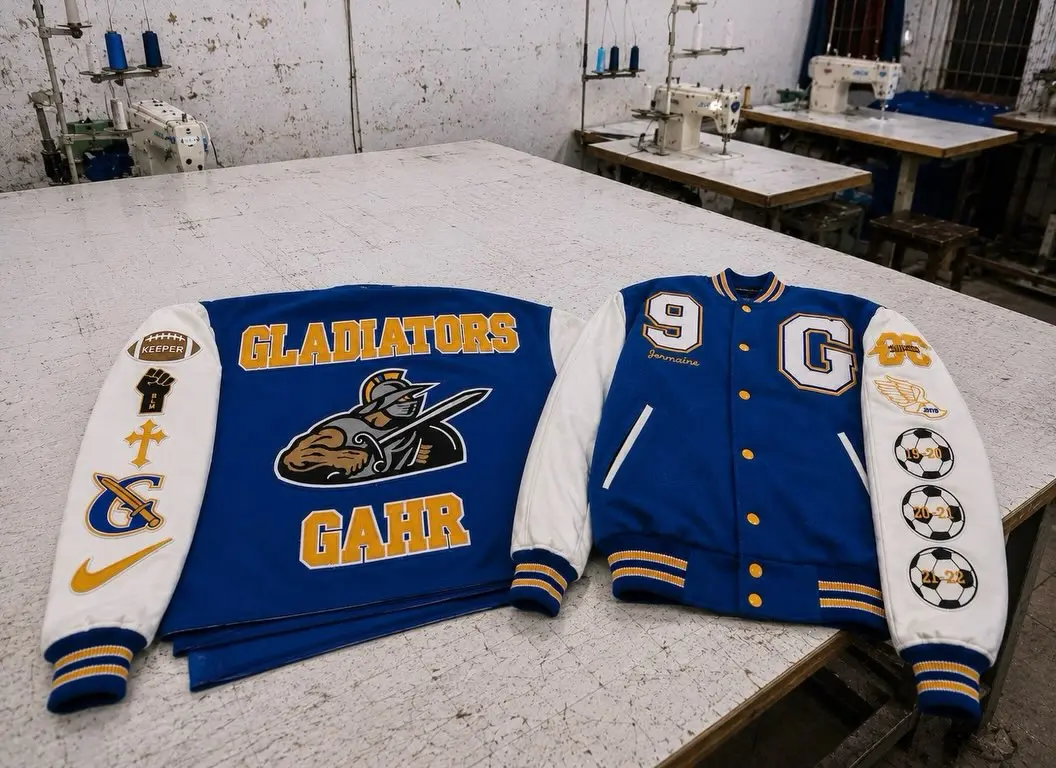 Blue varsity jackets with Gladiators embroidery laid out in the workshop